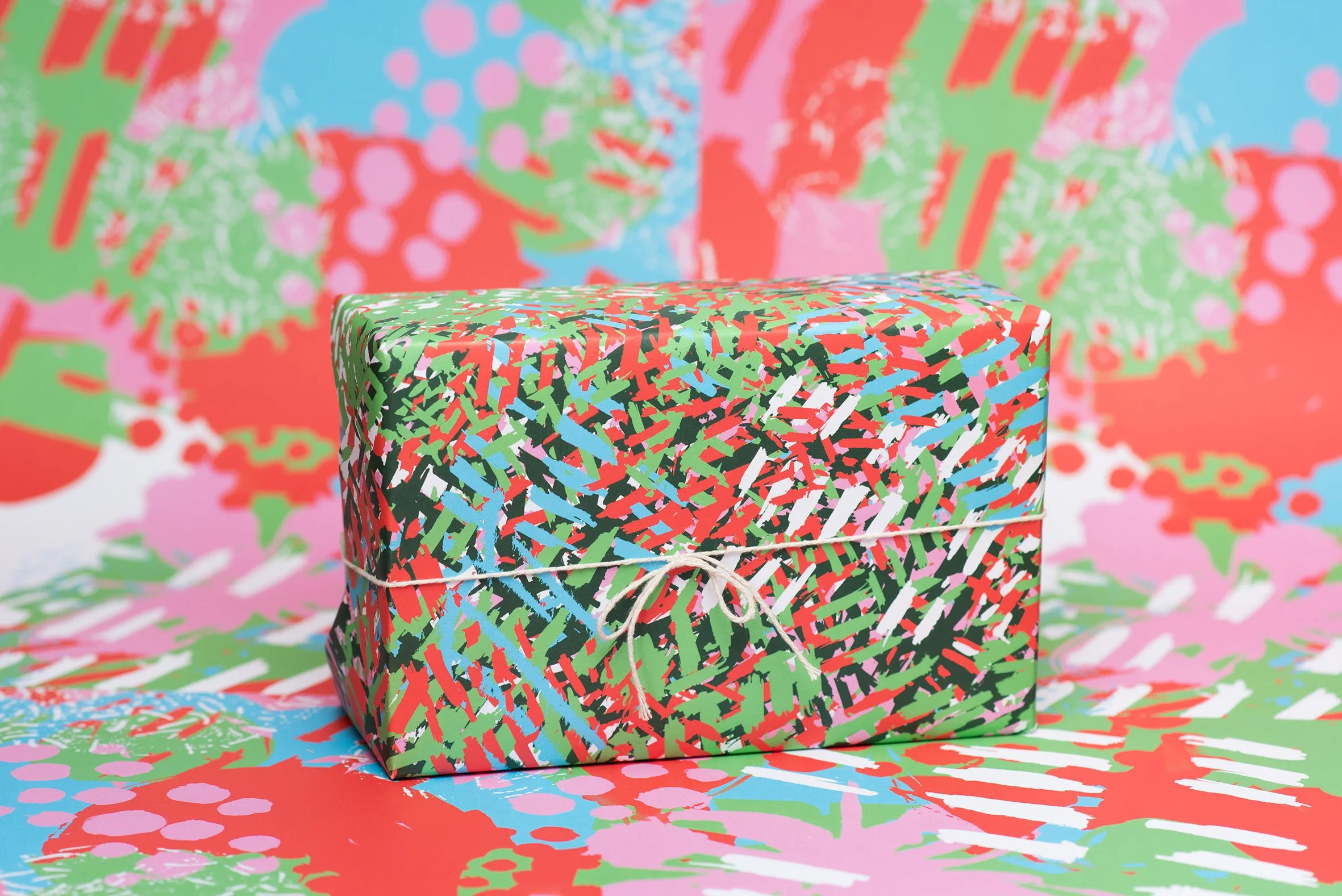 Roscher Creative uniquely colourful hand painted designs created for wrapping paper project with scratchy marks in red, green, white and cyan.