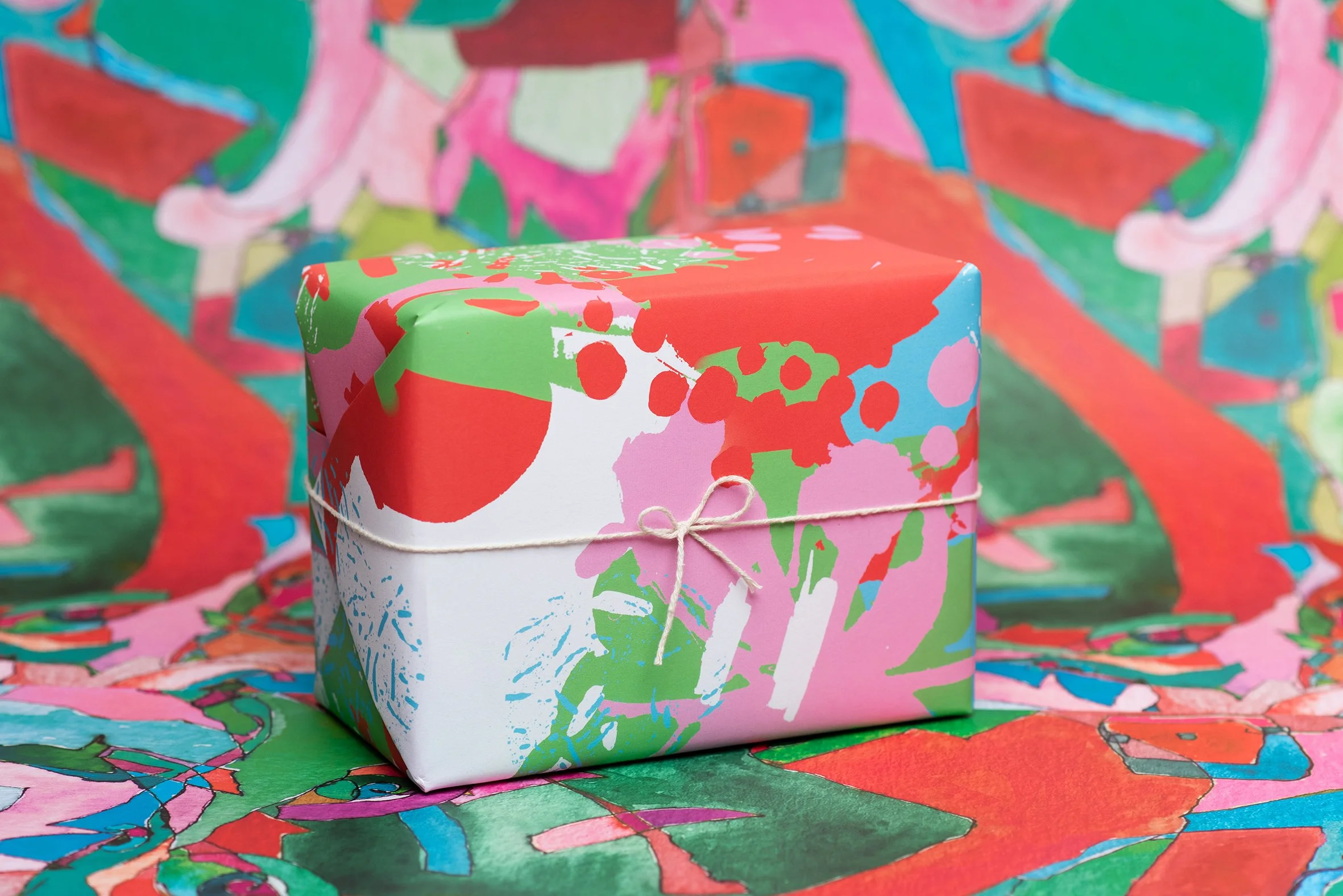 Roscher Creative uniquely colourful hand painted designs created for wrapping paper project with marks and dots and hand painted shapes in pink, red, green, white and cyan.
