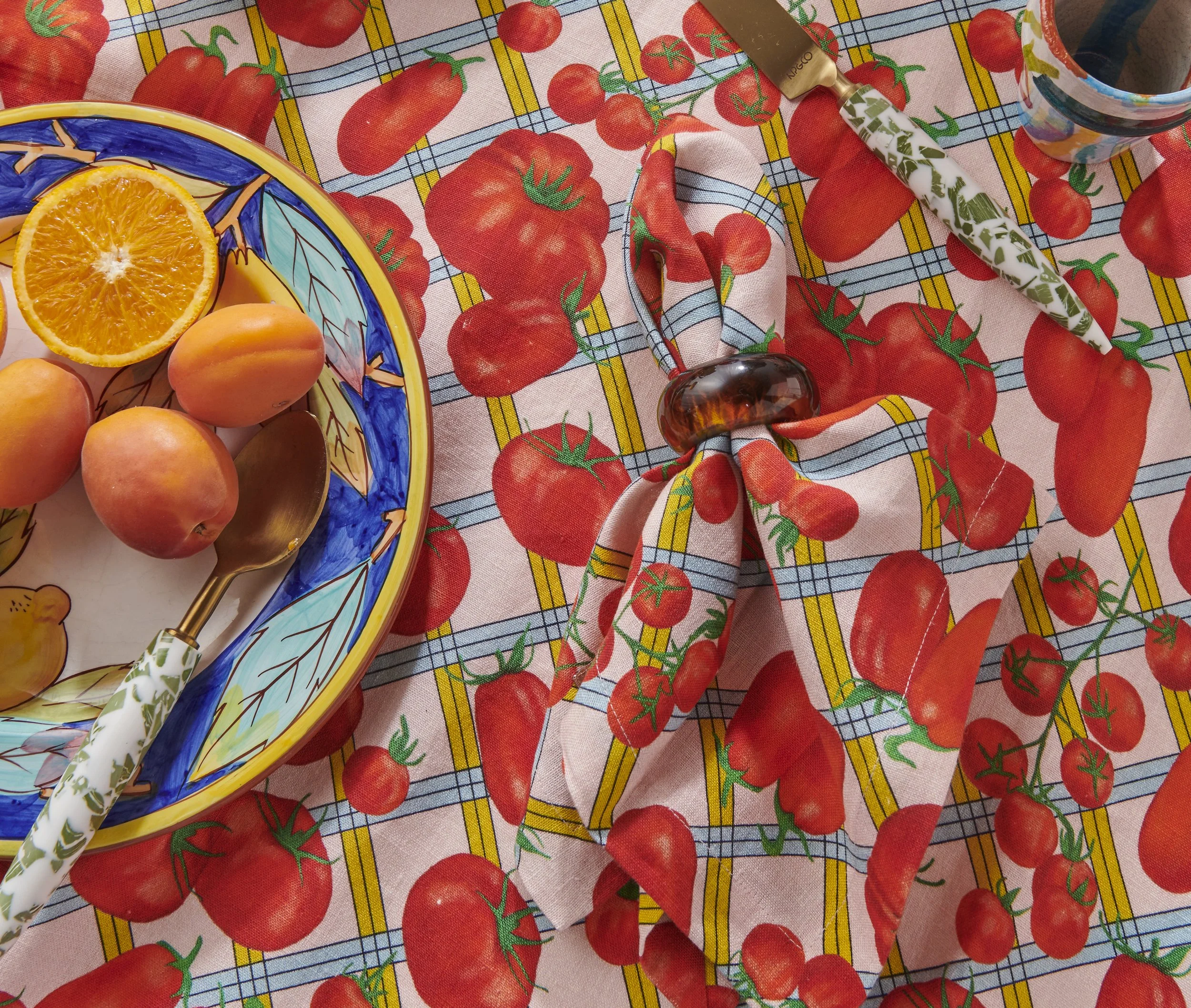 Kip&Co repeat print textile design for bedding, homewares and apparel. Bright red hand drawn tomatoes on a checked table cloth print background of pink, yellow and blue