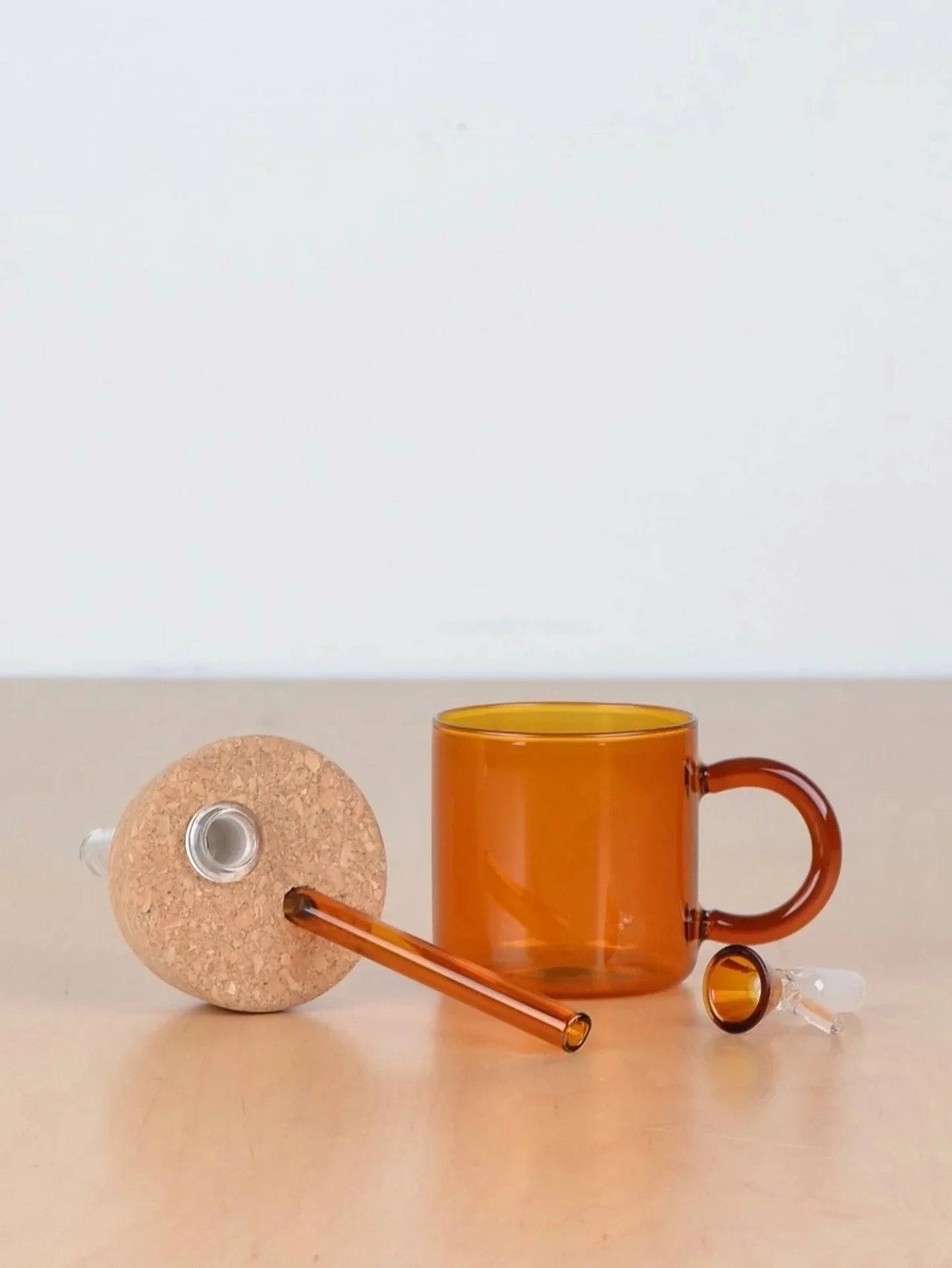 The Straw Cup was born when US manufacturing tariffs killed my glassware line. I had a surplus of slightly imperfect mugs in the studio looking for a use&mdash;with the addition of an existing cork from the Slow System (another victim of tariffs) and