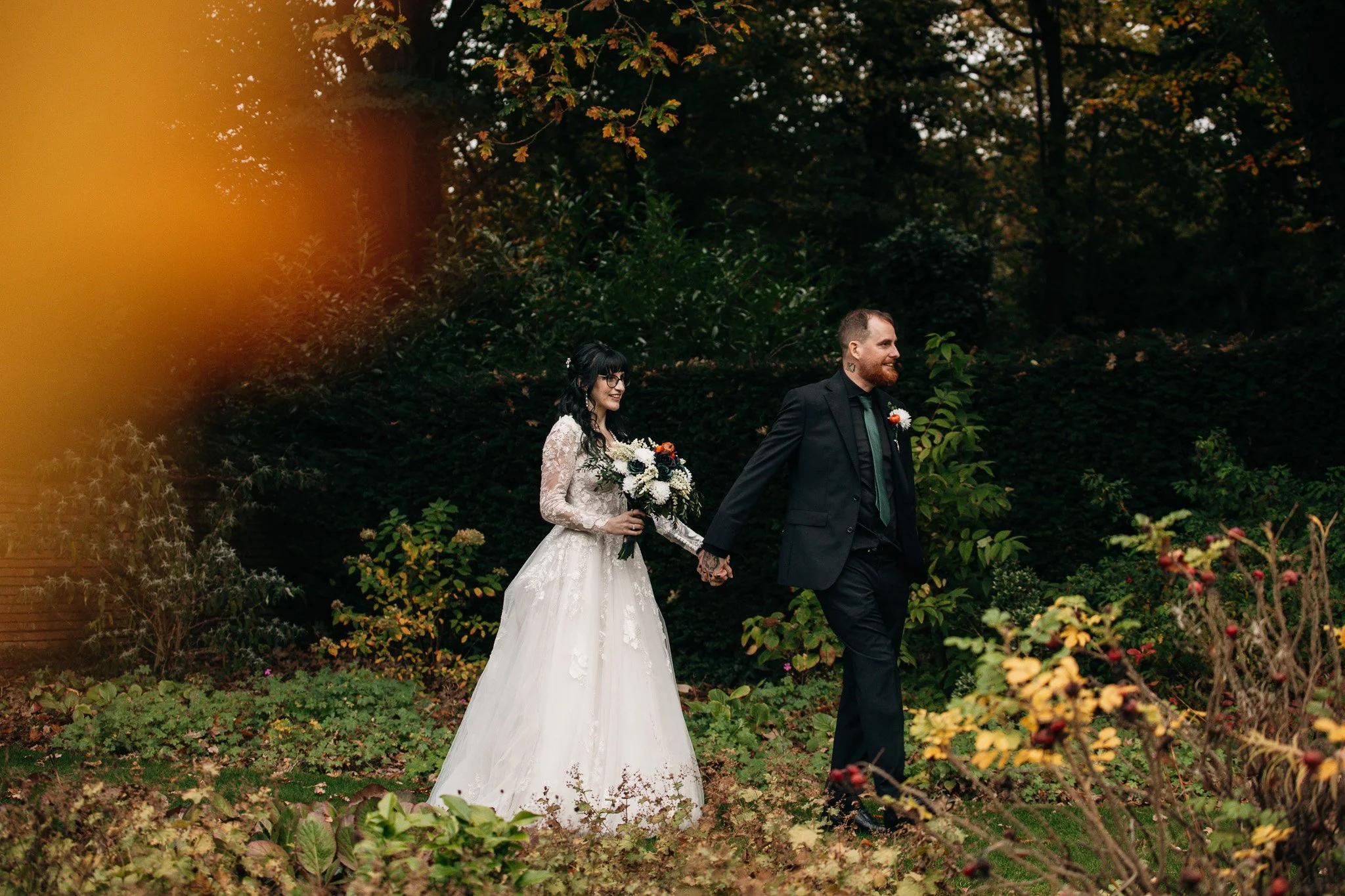 A happy couple on their wedding day, on a walk in the woods at New Place Hotel in Hampshire.