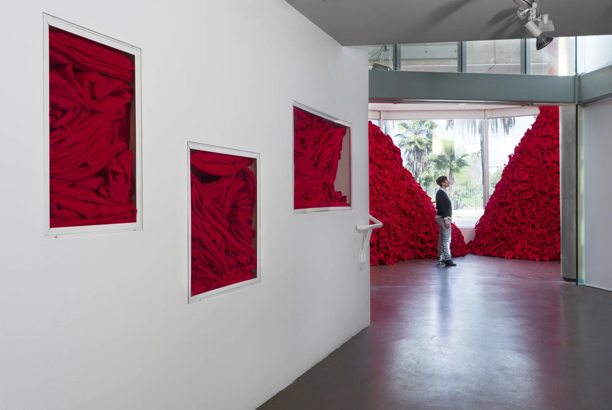 Installation View (Craft & Folk Art Museum, 2015) The Pile, 2014 Single Channel HD Video Projection with Sound (16mm Film), TRT 12:00, Looping; Digital C-Prints; Hand-Stitched Red Felt Objects Installation Dimensions Variable