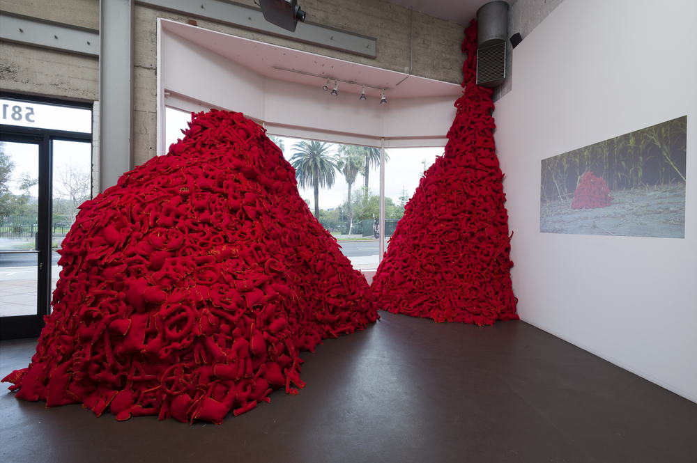  Installation View (Craft &amp; Folk Art Museum, 2015)   The Pile,&nbsp; 2014 Single Channel HD Video Projection with Sound (16mm Film), TRT 12:00, Looping; Digital C-Prints; Hand-Stitched Red Felt Objects Installation Dimensions Variable 