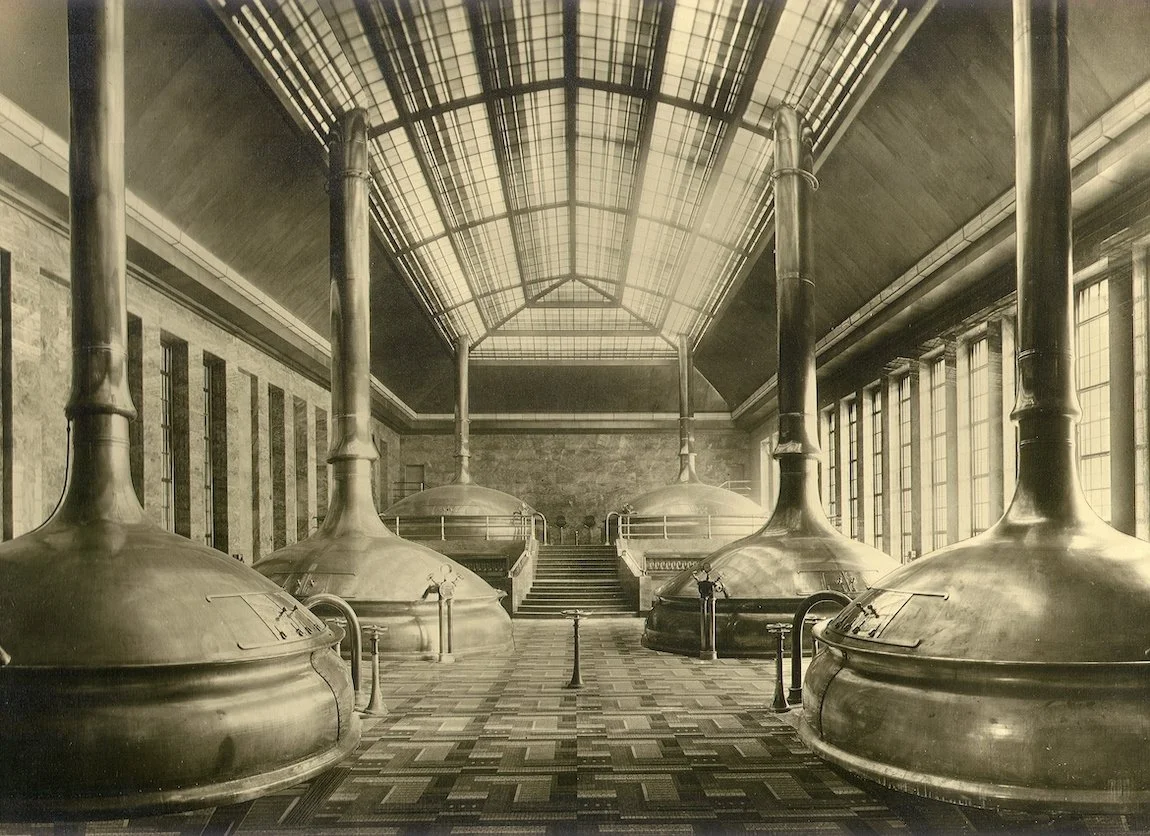  Interior view of teh brewhouse around 1930, featuring monumental copper brew kettles, walls made of gray-blue marble, elaborate floor mosaics, and windows with coloured crystal glass. 