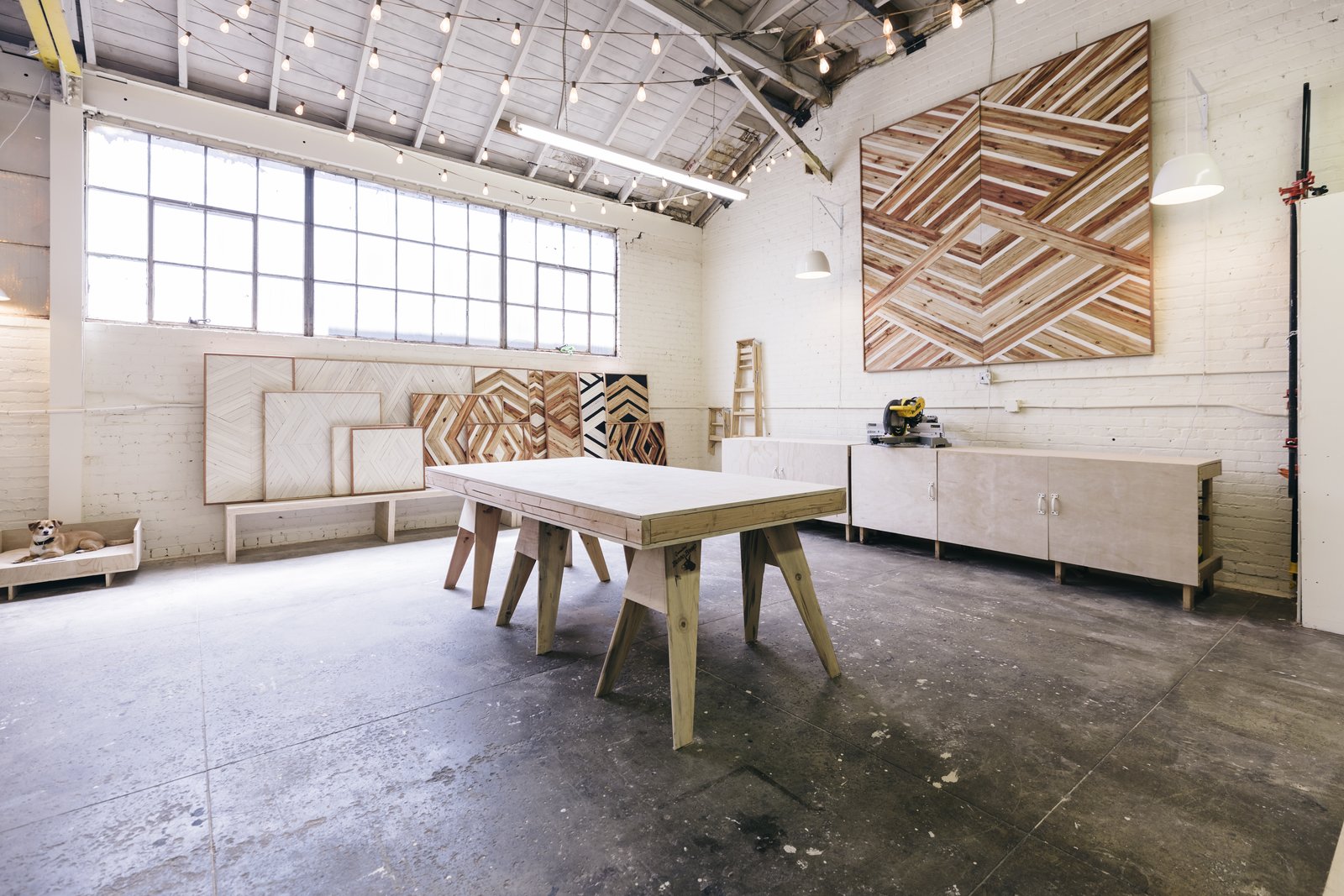 A view of the workspace in Zee's studio with saw table on the right.