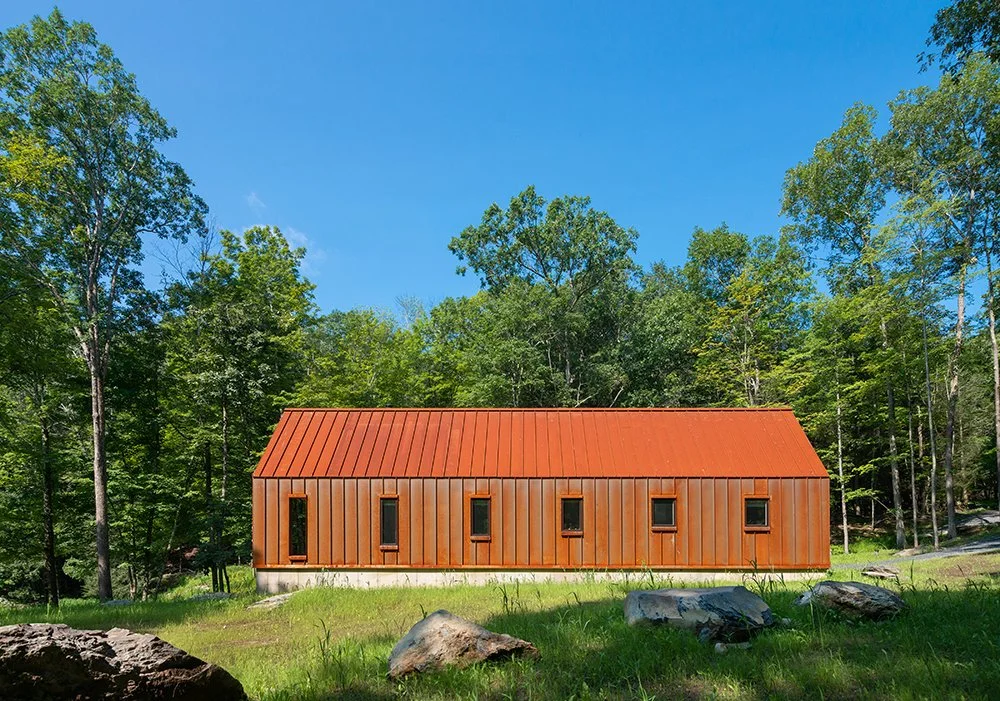The Pond House has a standing-seam roof and wall panels made of Cor-Ten steel that throw the forest around it into relief. (Bjorg Magnea)
