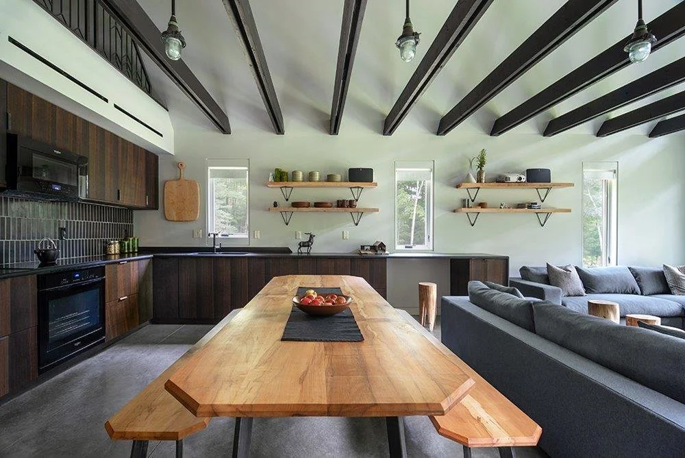 In the kitchen, a Heath-tiled backsplash sits over leathered granite counters. Smoked-oak cabinet doors from Reform cover Ikea cabinets. (Bjorg Magnea)