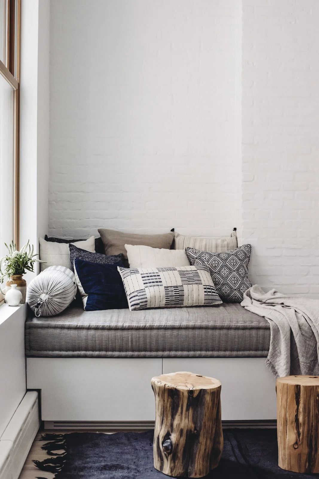 The built-in day bed by JFL Custom Builders provides a cozy corner. Topped with a pillow assortment by Walter G textiles, Bungalow Decor, and Injiri, it’s ideal for cuddling up with a book and a blanket. West Elm wood stumps and an antique hemp rug round out the space with some added depth. (Chloe Leroux)