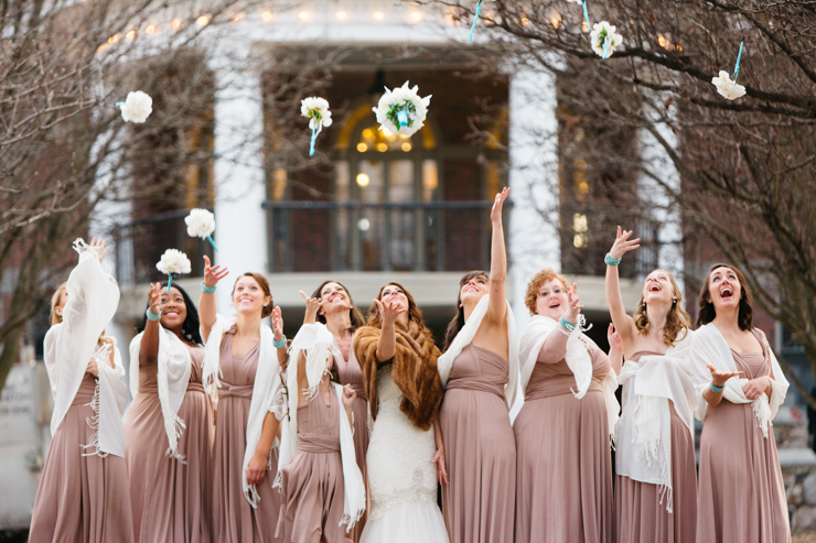 Bridesmaids throwing flowers wearing pink long gowns