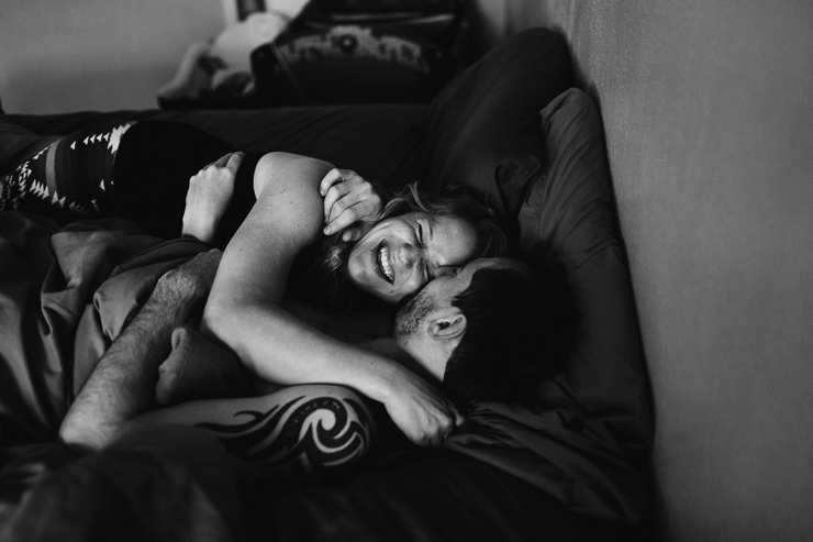 Lifestyle photography of man and woman snuggling in bed
