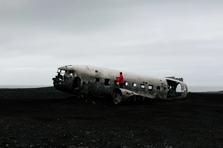 Man standing on the US Navy DC3 Wreckage at Solheimasandur, Iceland