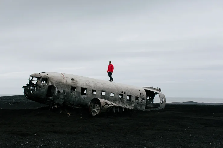 Man standing on the US Navy DC3 Wreckage at Solheimasandur, Iceland