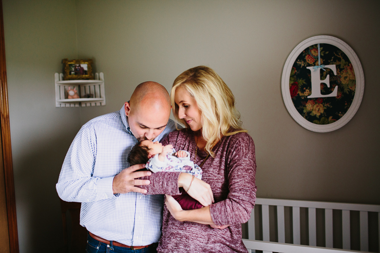 Mom and Dad with their newborn baby girl in her nursery photography 