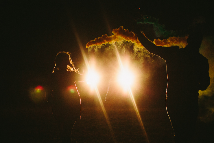 Nolan and Alyssa's Rustic Countryside engagement session dancing with smoke bombs in the headlights of a truck