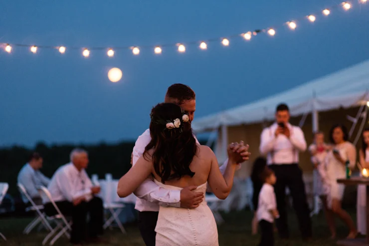 bride and groom's first dance outdoor countryside wedding reception in a big white tent