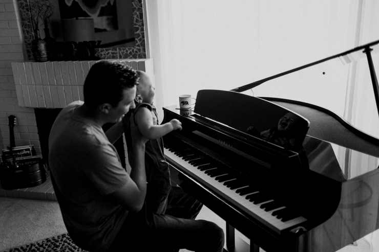 Father and one year old son playing the paino together photography in Colorado