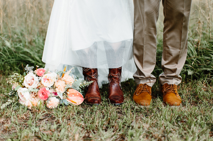 Bride and Groom's shoes with cowboy boots and stunning florals by Splendor Of Eden