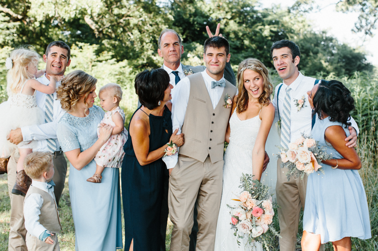 Fun family photo with bride and groom outdoor on family farm