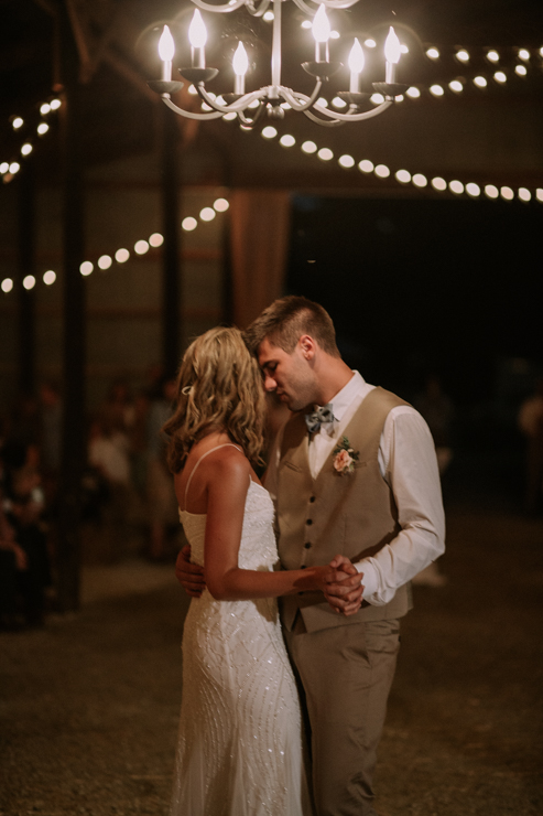 Wedding Reception at Grandparents' family farm and barn decorated with hay bales, quilts, chandeliers, and edison bulbs