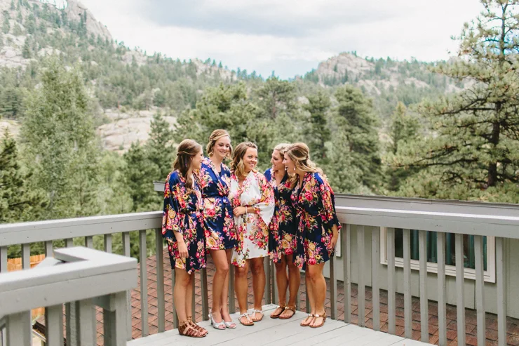 Bridesmaids in floral robes standing in front of the mountains in Estes Park on wedding day