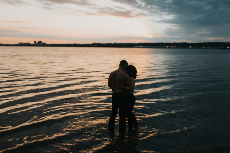 Intimate photography of a married couple in the water together partially nude 
