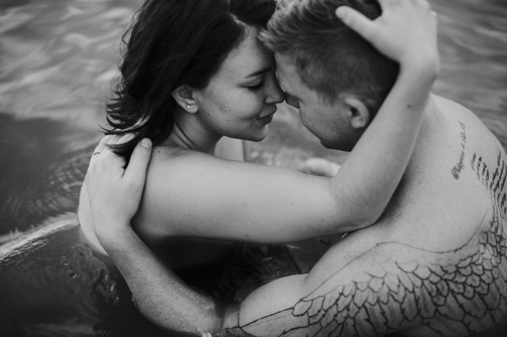 Intimate couple photography. Photography of a married couple with amazing tattoos in the water together partially nude