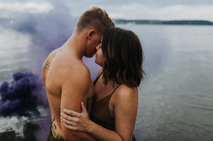 Intimate couple photography nude in the water with a purple photography smoke bomb