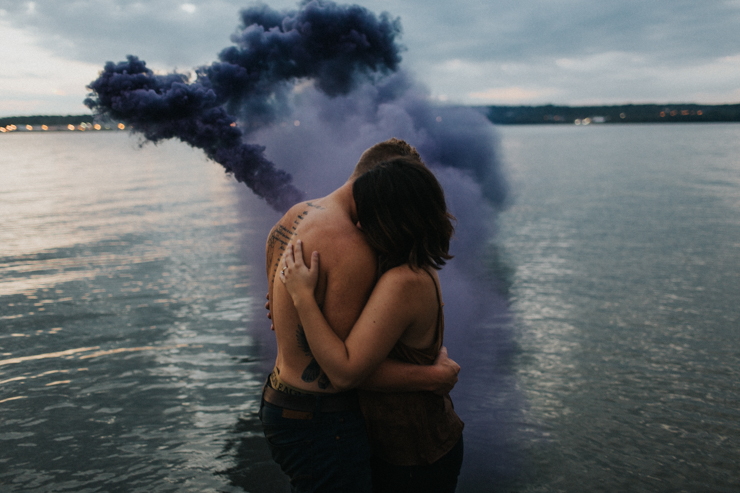Intimate couple photography nude in the water with a purple photography smoke bomb 