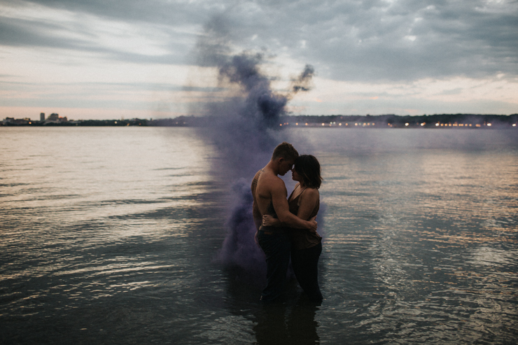 Intimate couple photography nude in the water with a purple photography smoke bomb