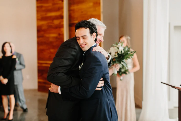 Father hugging groom at wedding