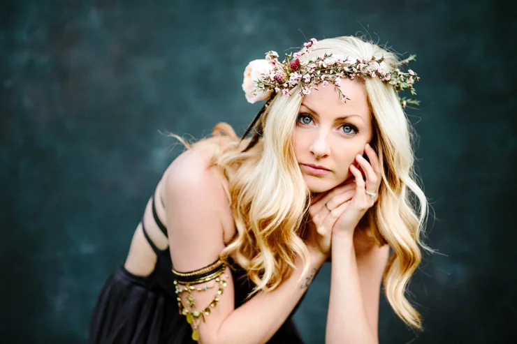 Girl posing in front of a dark blue backdrop wearing free people boho clothing and flower crown
