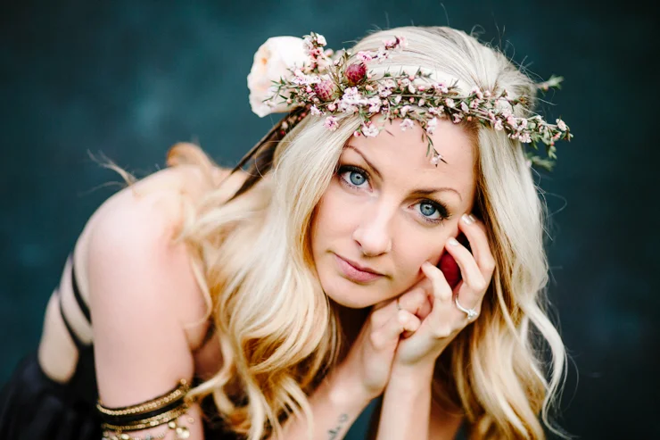 Girl posing in front of a dark blue backdrop wearing free people boho clothing and flower crown