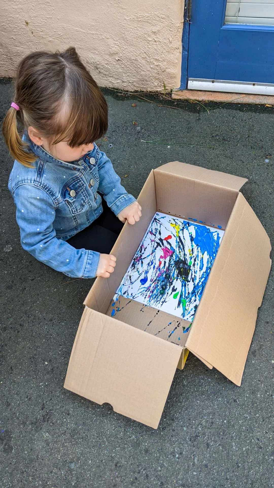 A young Kinderwerkstatt student participating in a marble art activity.