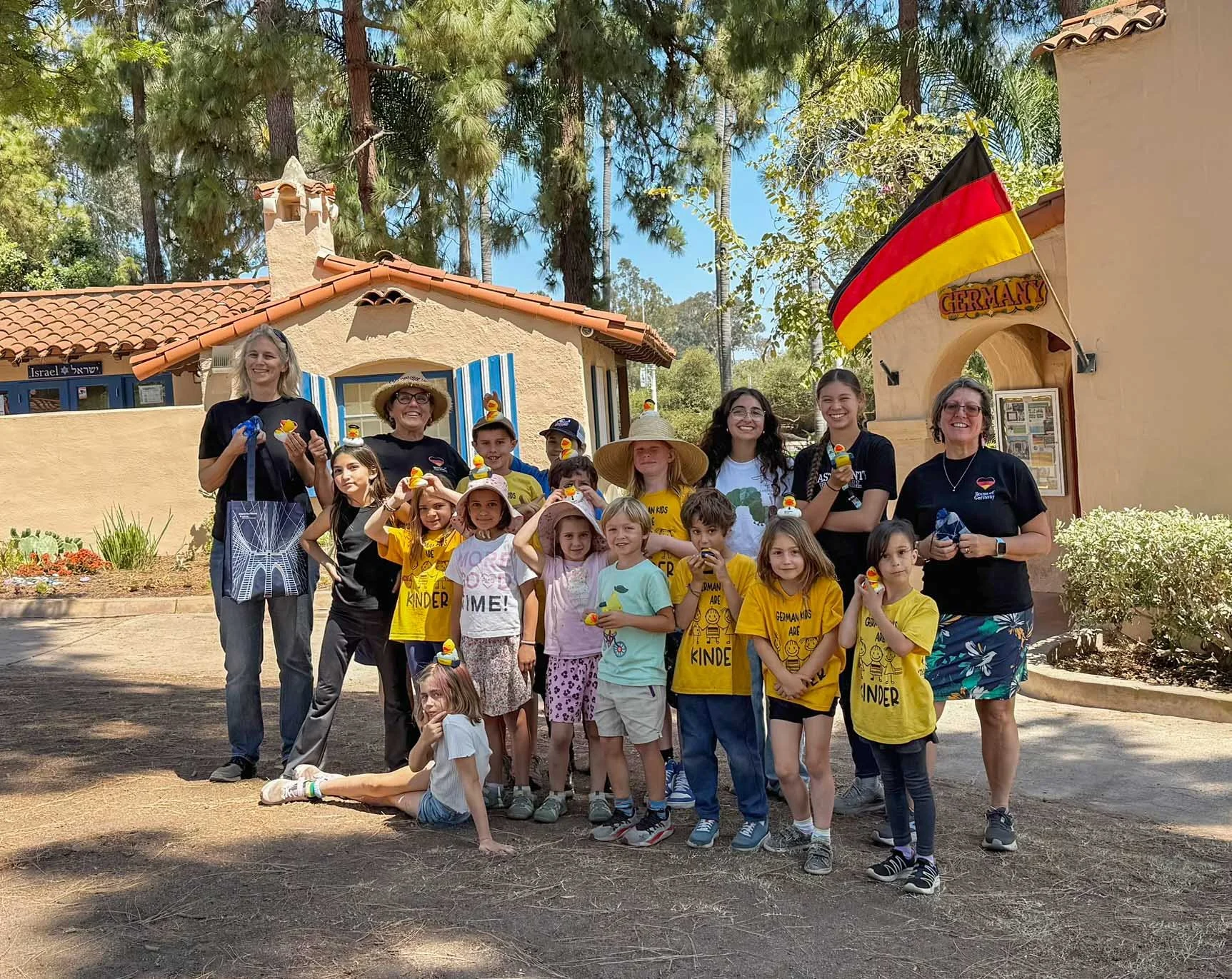 Group of summer camp participants and their teachers posing near the International Cottages.