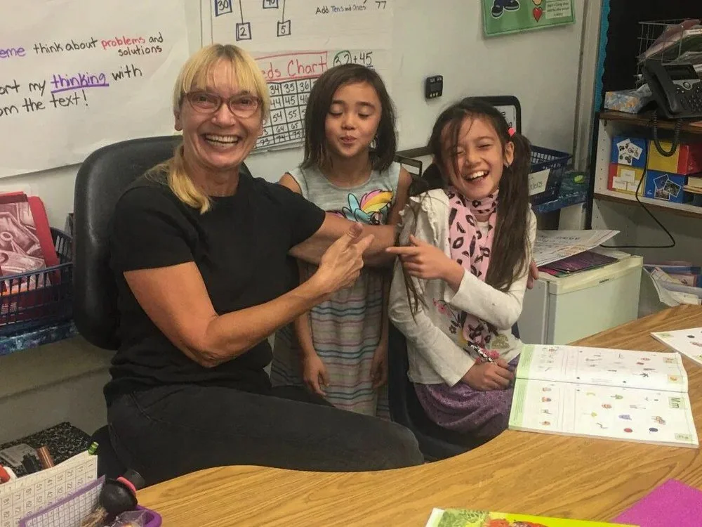 Two Kinderwerkstatt students goofing around with their teacher.