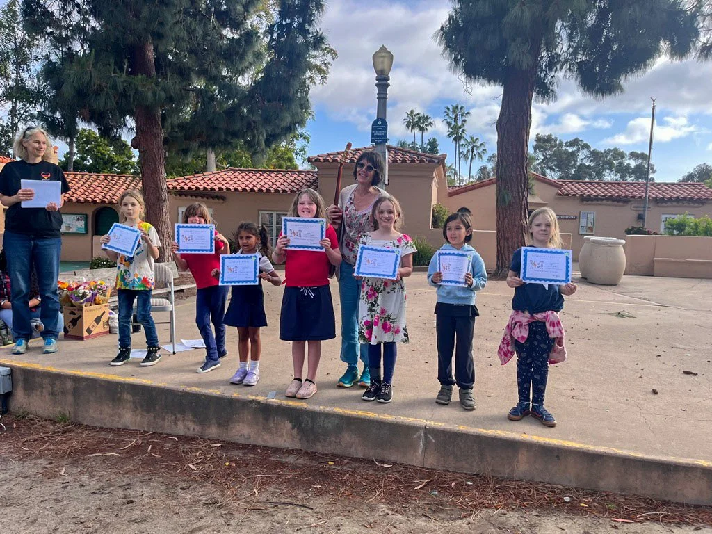 Kinderwerkstatt students holding their certificates at a graduation ceremony.