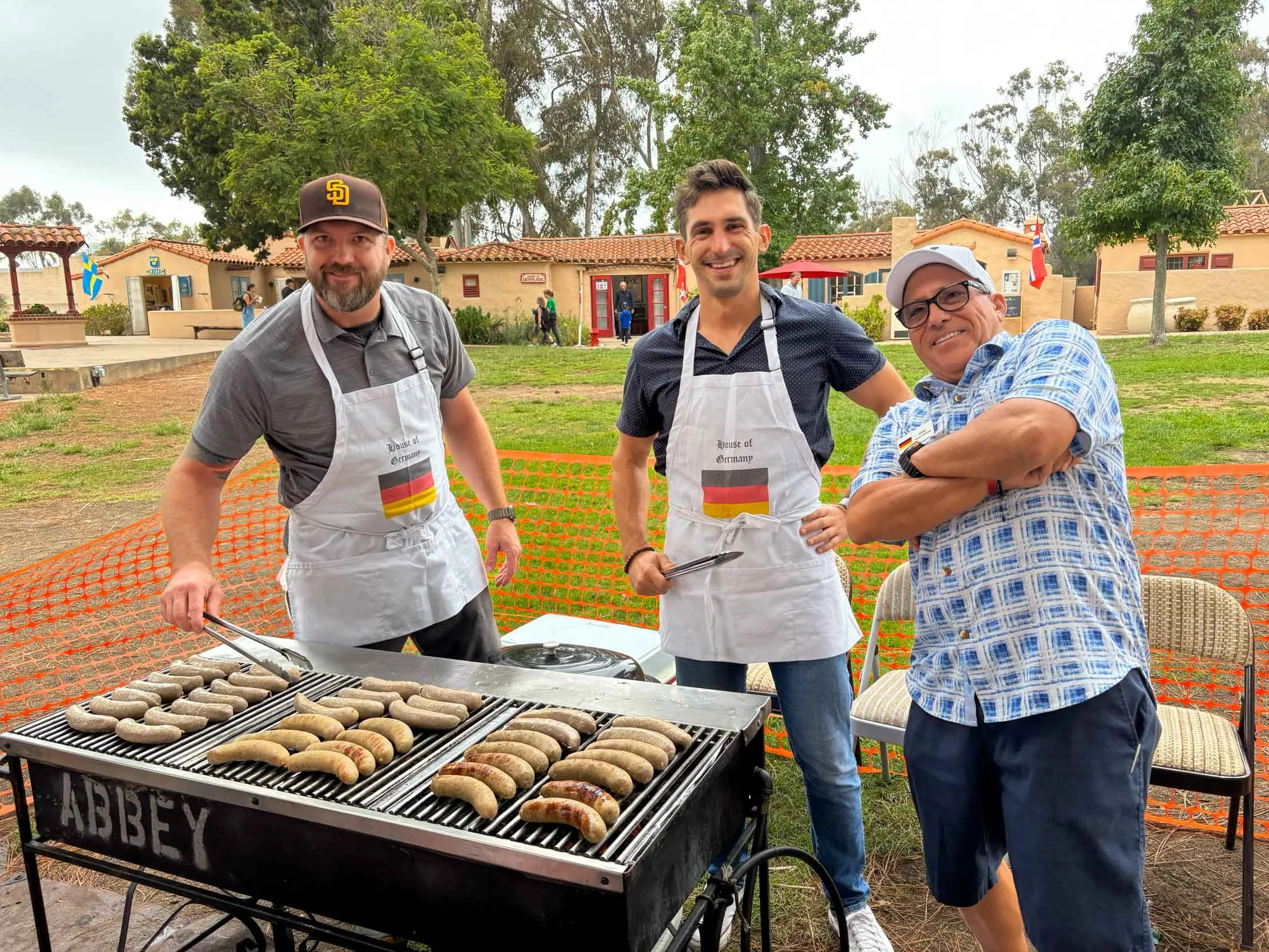 Vice President Michael Salazar with two House of Germany members grilling sausages at the Lawn Program in 2025