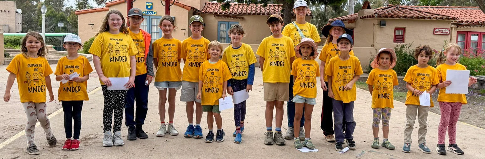 Group of summer camp participants posing near the International Cottages.