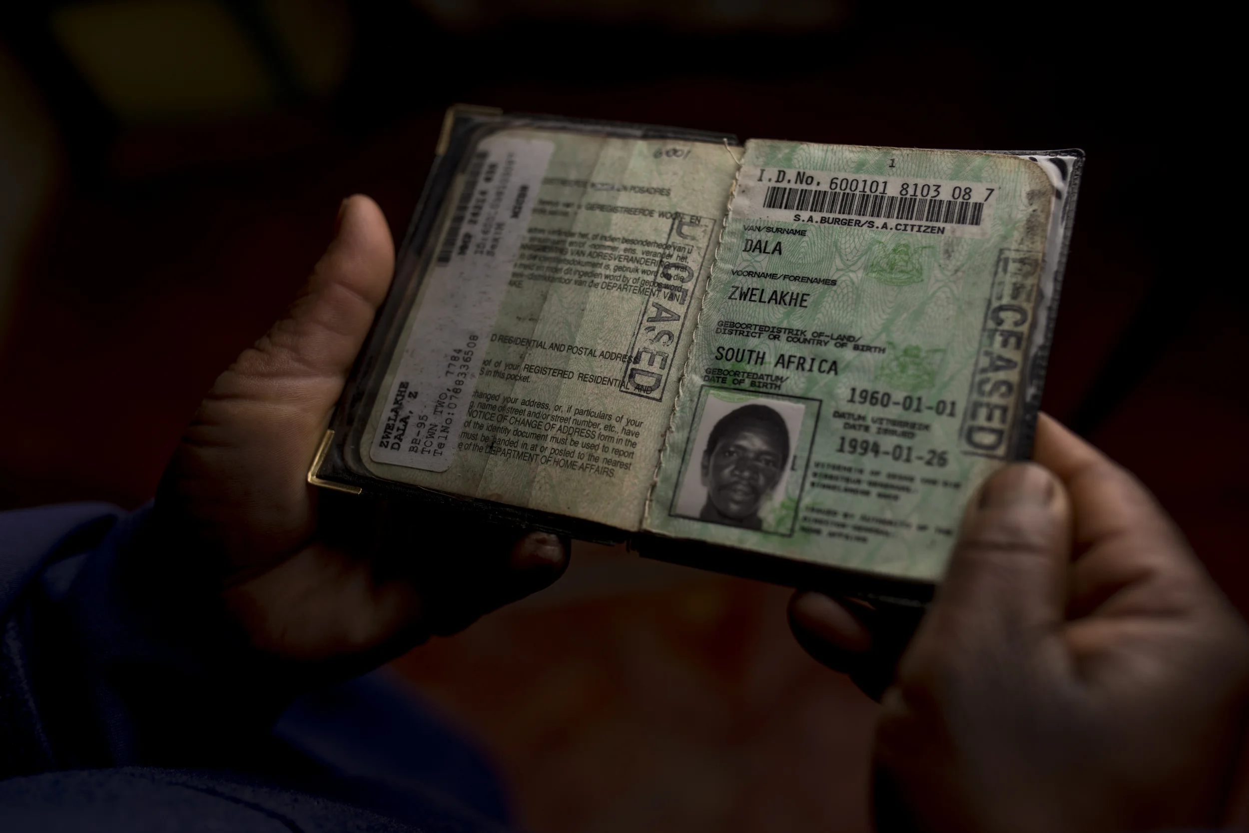Mrs Dala holding her husbands ID book stamped "DECEASED"