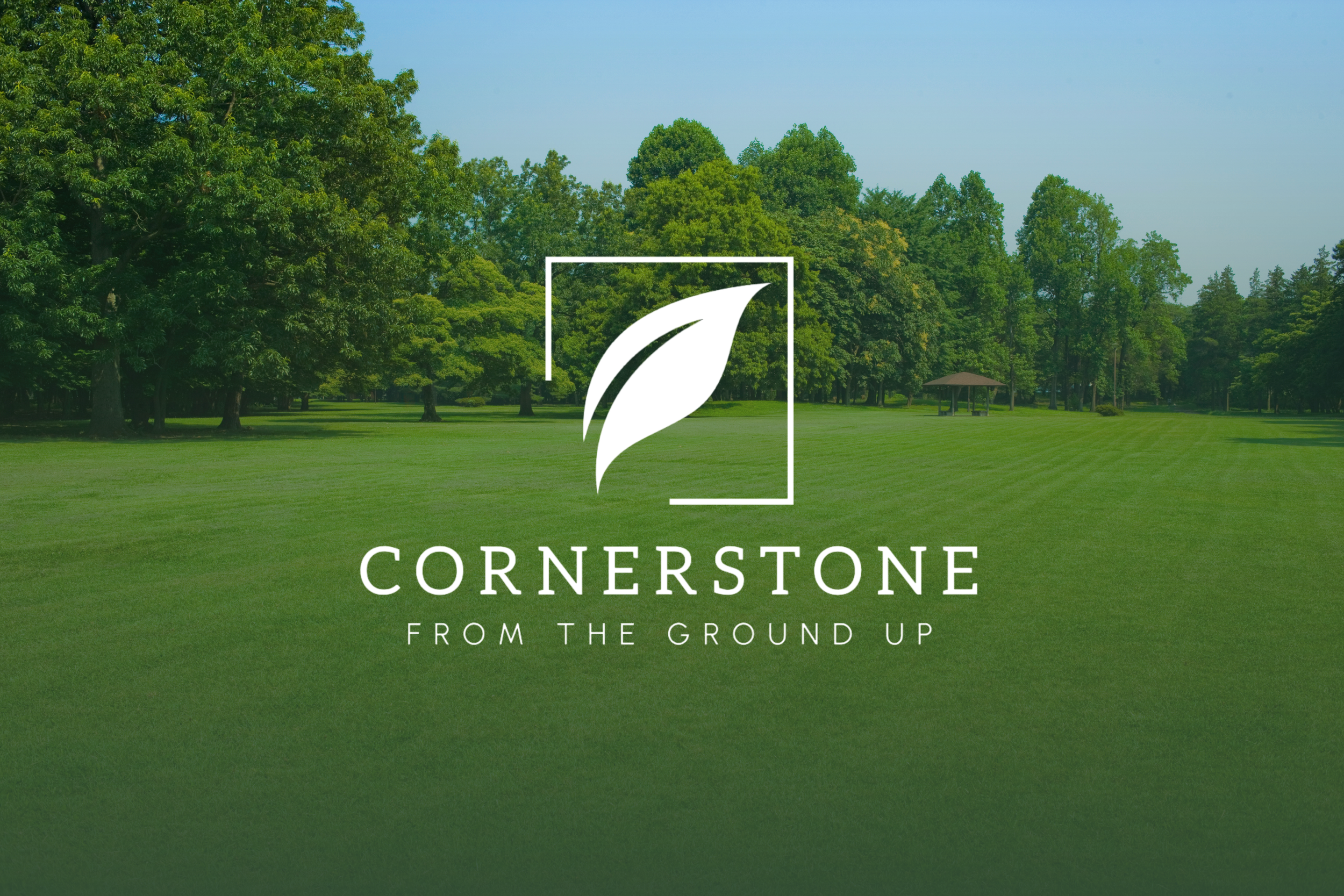 Cornerstone Lawn Services company logo with the slogan "From the Ground Up" centered over a lush green landscape and trees.