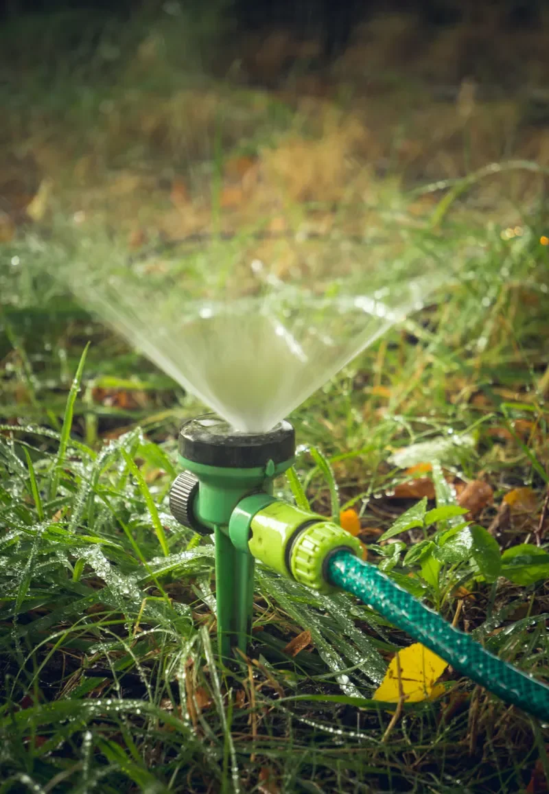 Lawn sprinkler watering green grass for Cornerstone Lawn Services.