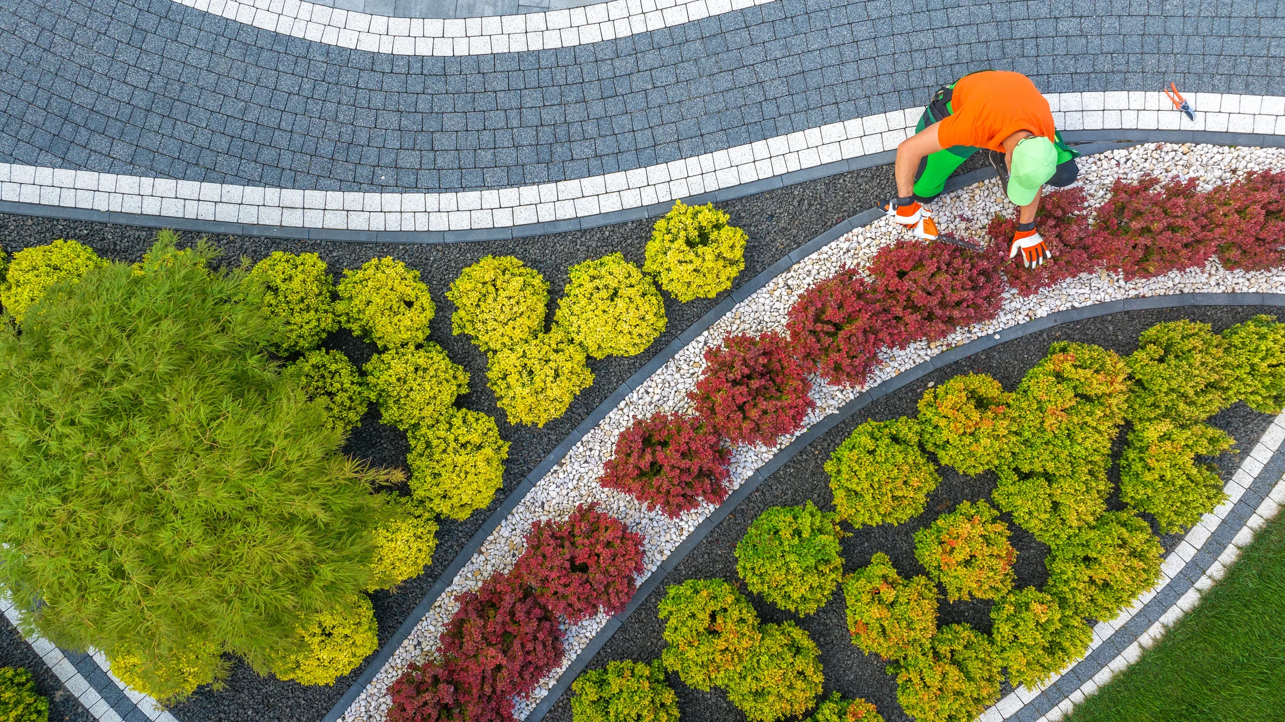 gardener-shaping-bushes-and-laying-stones-on-pathw-2026-09-24-11-27-40-utc.webp