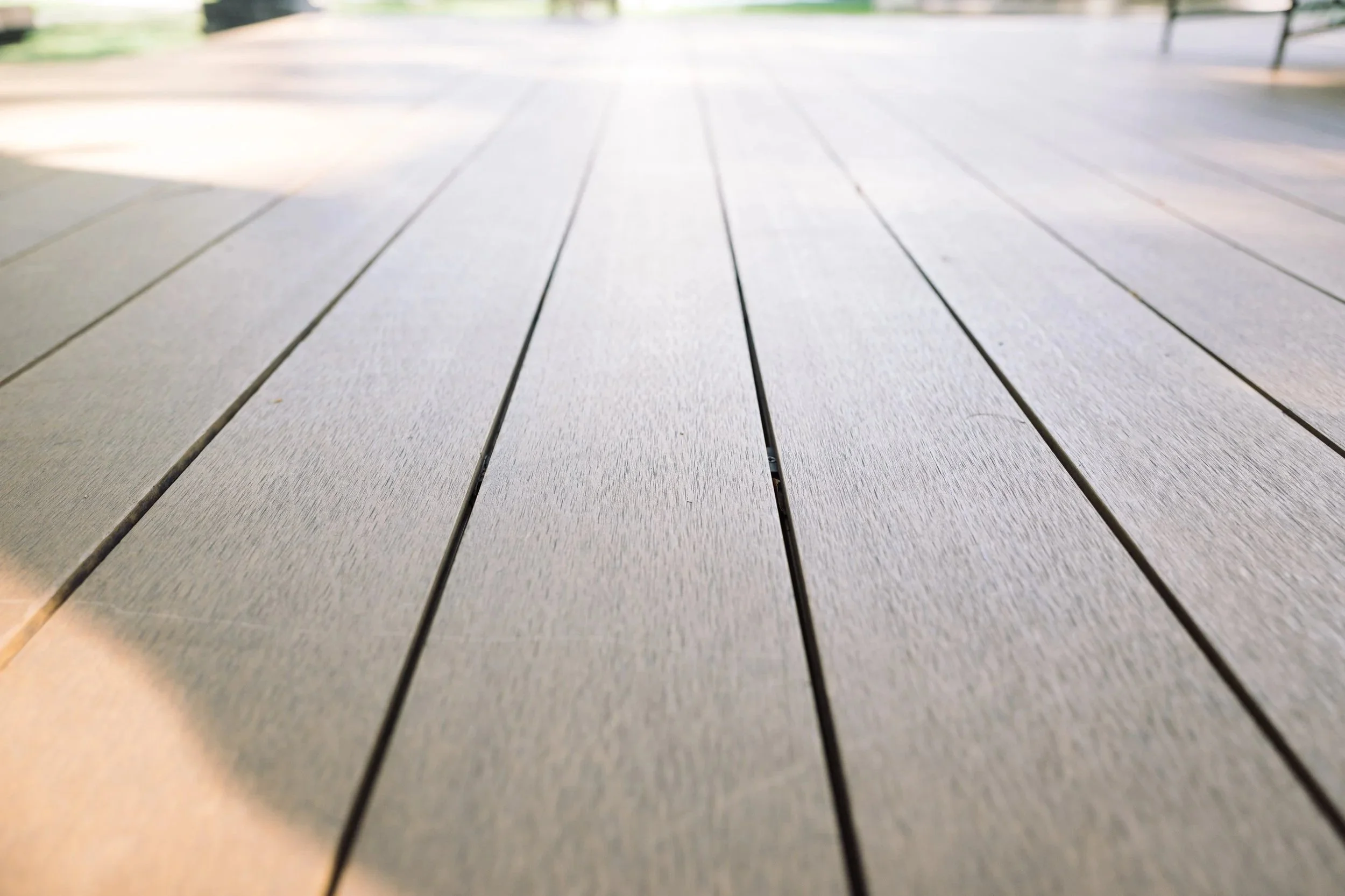 Close-up, low-angle view of smooth gray composite deck boards showing a clean, uniform finish.