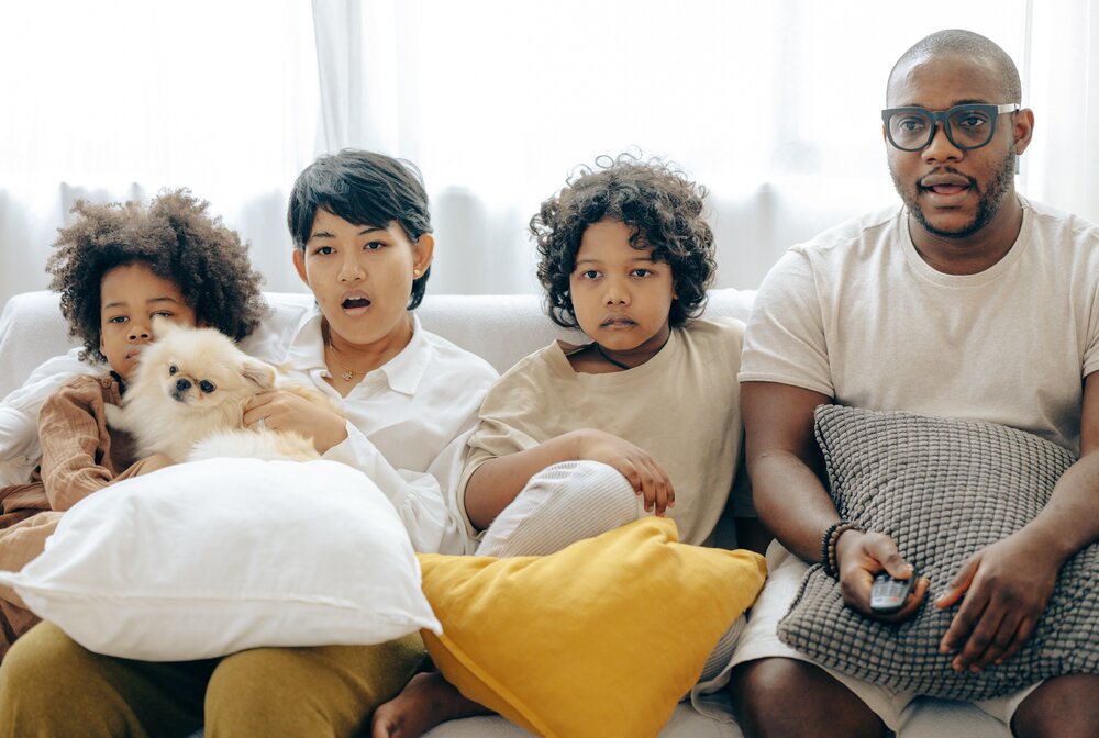 Image: https://www.pexels.com/photo/interested-multiracial-family-watching-tv-on-sofa-together-with-dog-4545955/