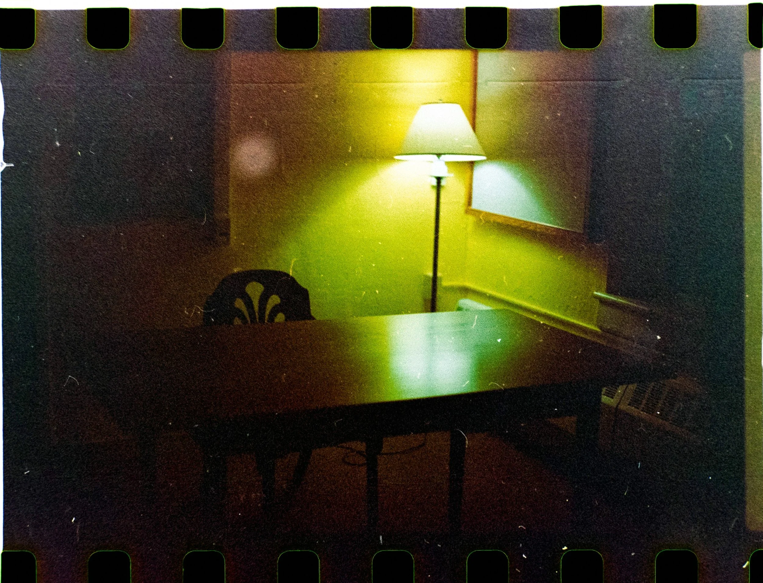 A vintage film reel and projector resting on a dark table