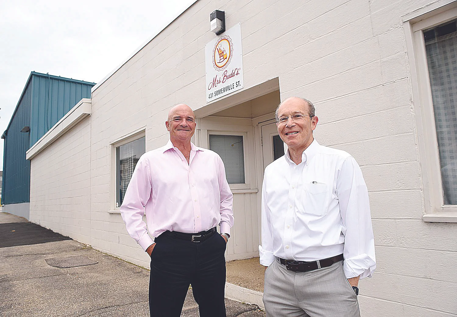 Mrs. Budd's owners Leo Sprecher, right, and Curt Marcott in front of the company's Manchester plant on Somerville Street on Tuesday. (DAVID LANE/UNION LEADER)
