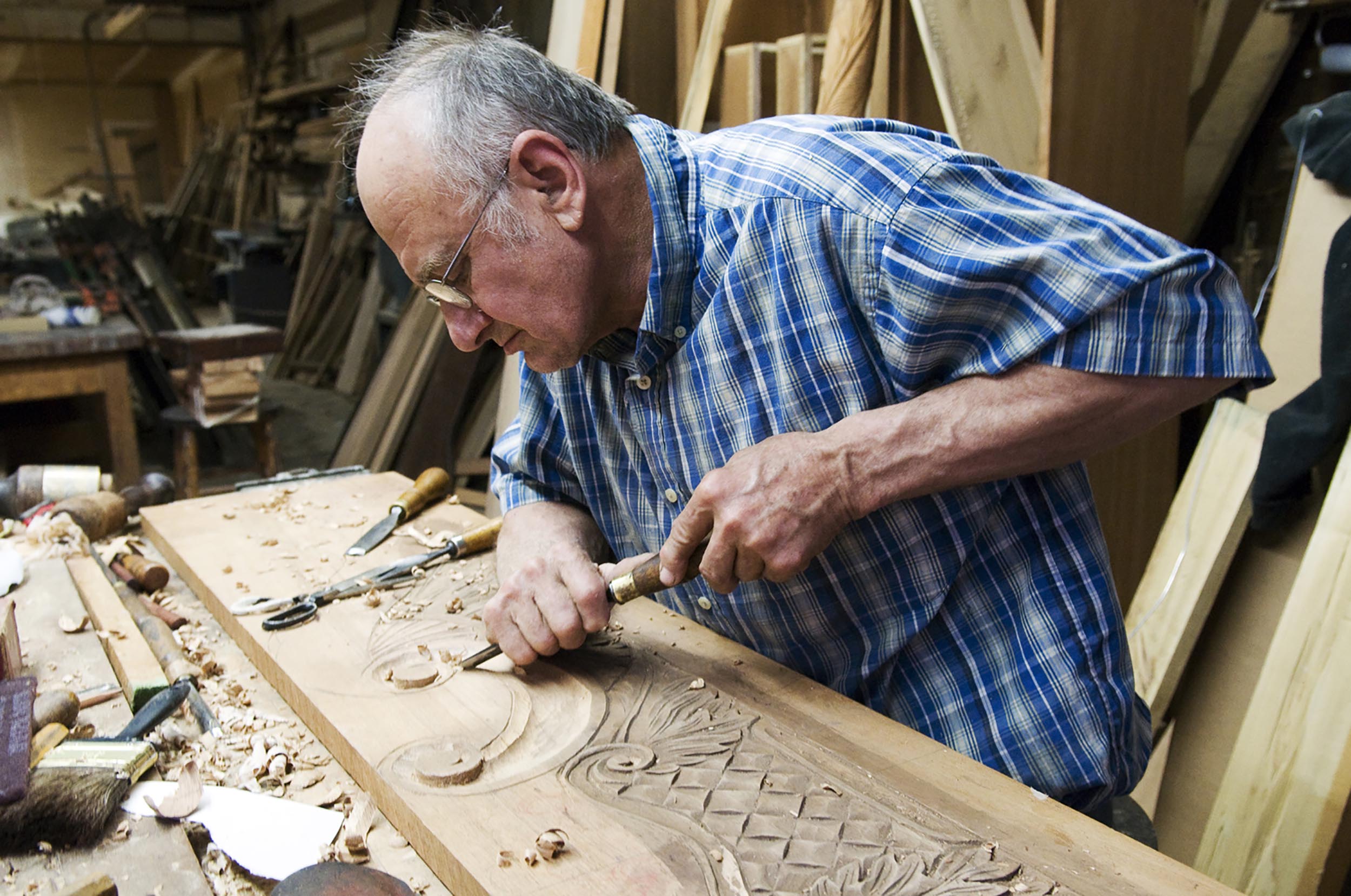 Joe Mazurek carves a headboard out of a peice of maghony at his shop in Camden, S.C. He uses 18th century construction techniques to build furniture.