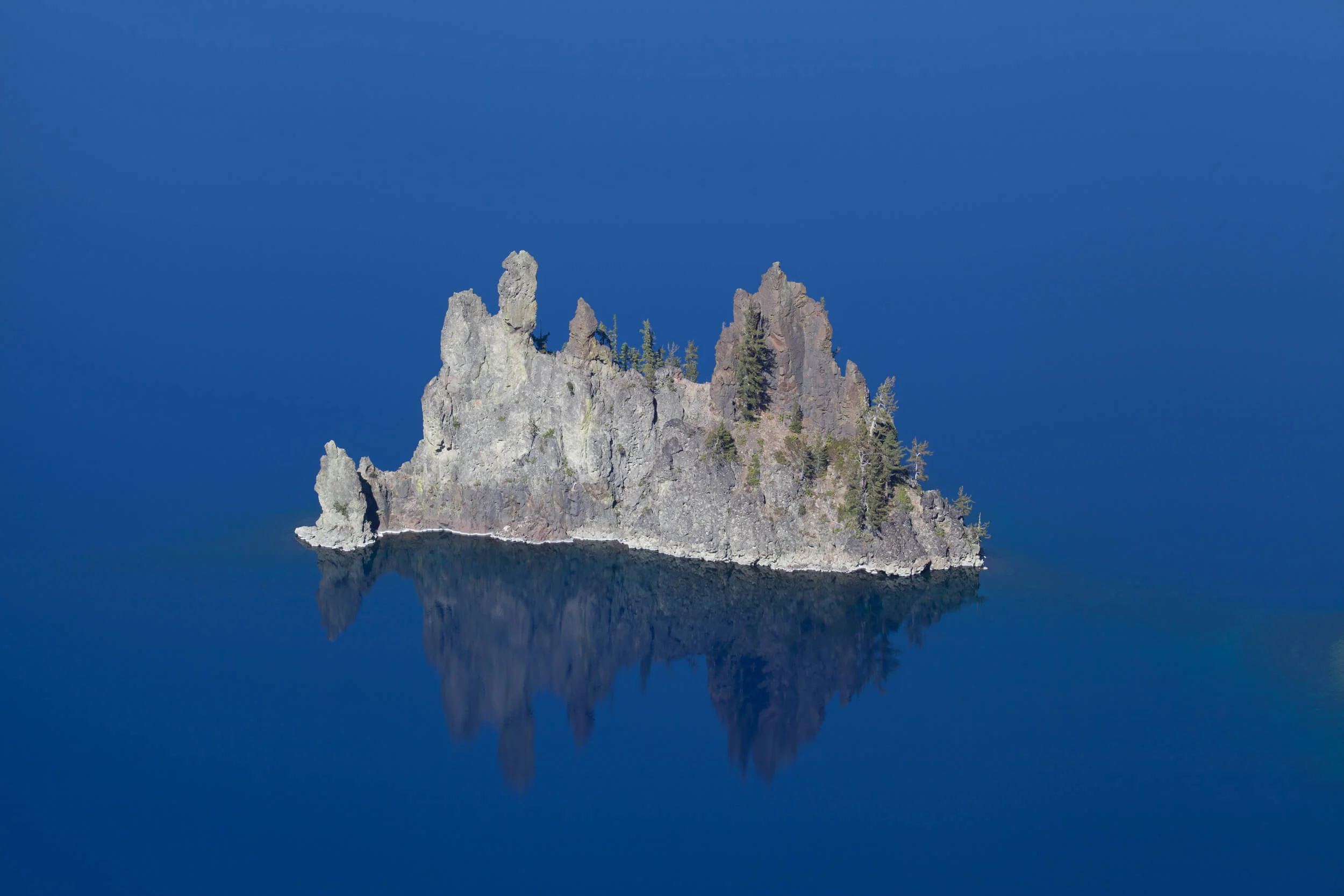Phantom Ship sailing the glassy waters of Crater Lake. 