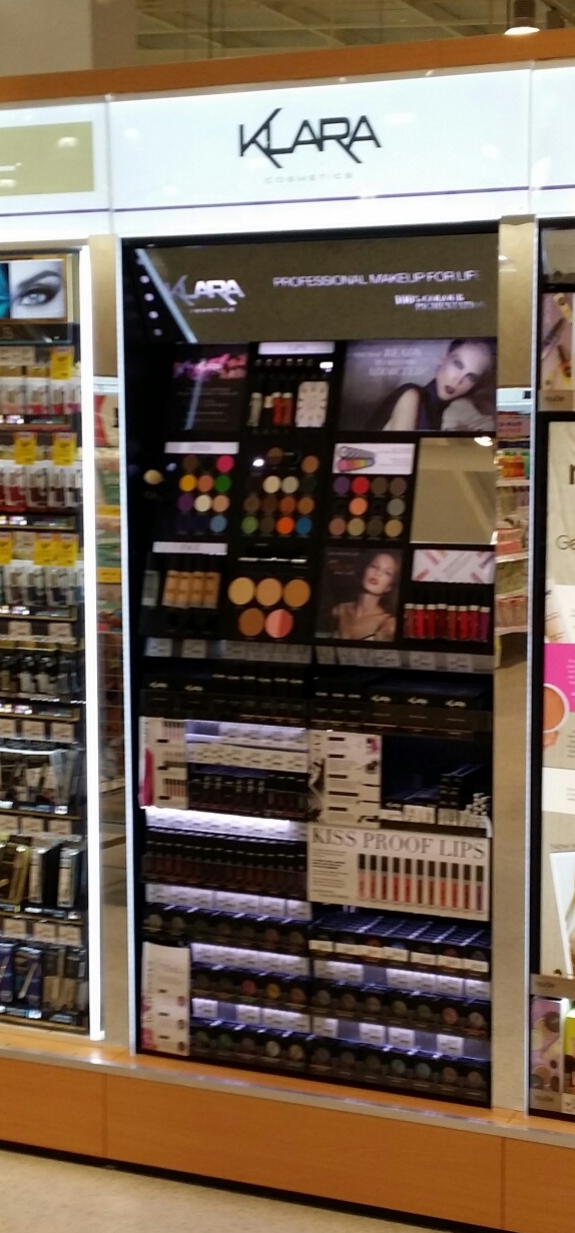 Klara Cosmetics Coles infill. Features etched backlit charcoal mirror, LED lighting, Tester panels with security retraction devices. Push feed stock trays from steel and acrylic.