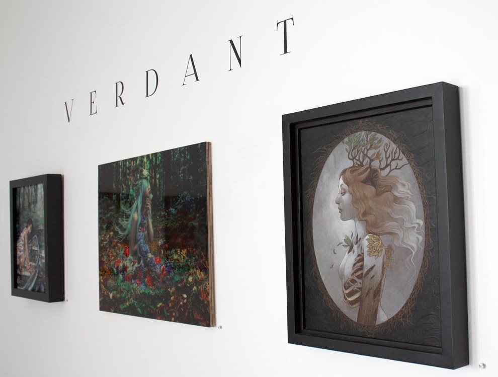 Display at Modern Eden's "Verdant" group show, photo courtesy of Modern Eden. Resin-glazed wood print pictured in middle of Kindra Nikole's "Of Withering Abundance."